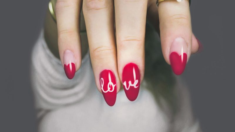 Red fingernails with "love" written on them
